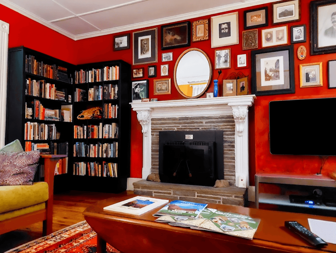 A view of in the living room from the couch of the fireplace and bookshelves