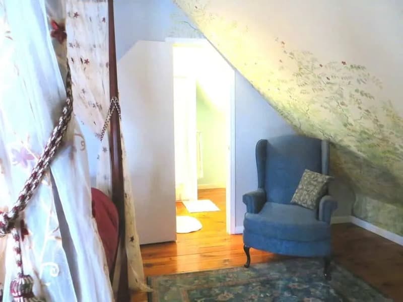 Cozy sitting area with armchair under the sloped ceiling in the Carmen Room