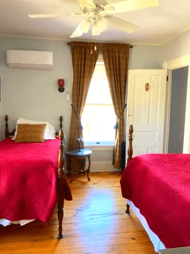 Second-floor bedroom in the Yogi Berra Suite with two twin beds, wood floors,