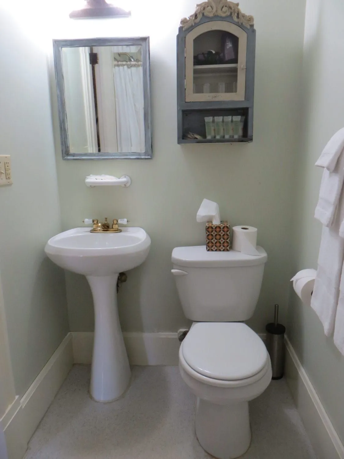 Private bathroom in the Yogi Berra Suite with pedestal sink, toilet, and mirror