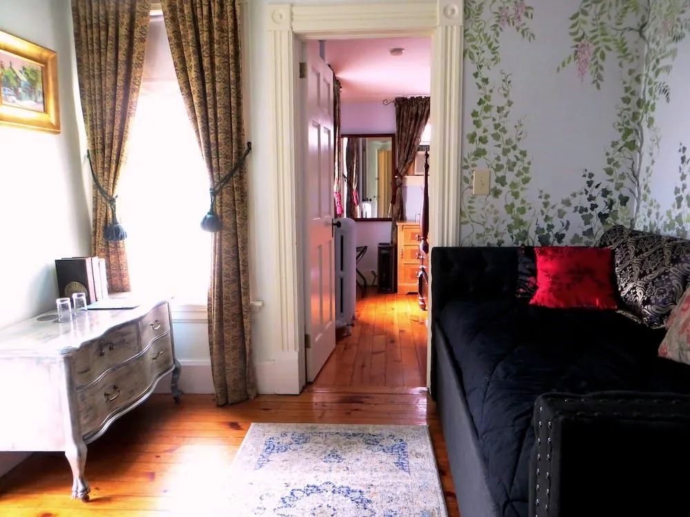 Private bathroom in the Satchel Paige Suite with bathtub and shower, sink, toilet, and window