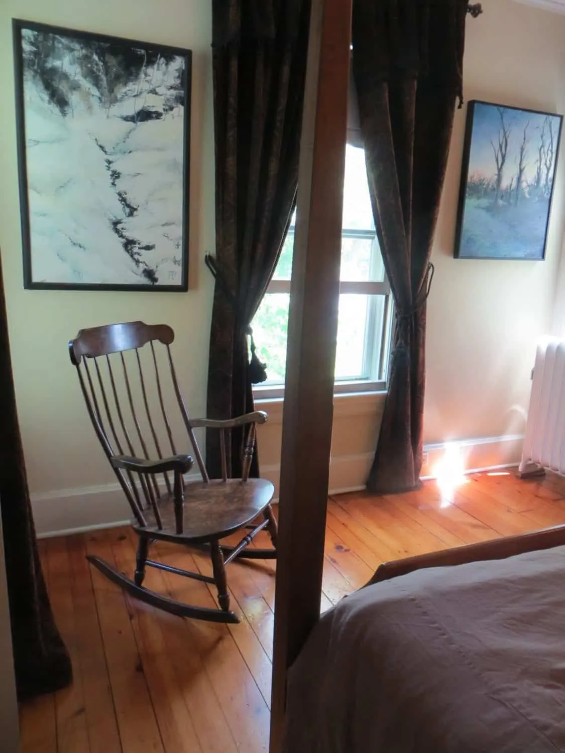 Bay window seating area in the Ozzie Smith Room with rocking chair, artwork, and natural light