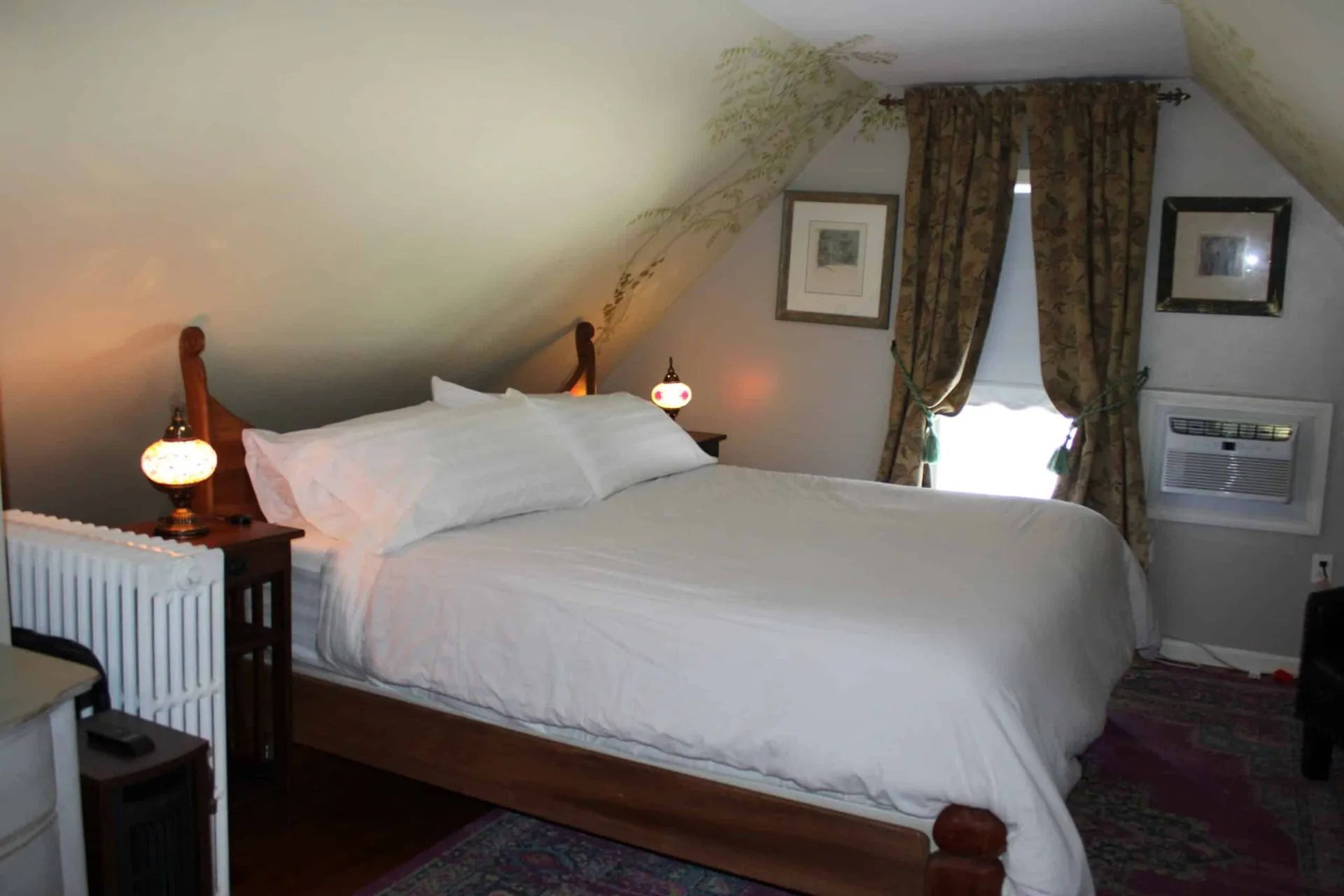 Alternate view of the Tosca Suite king bed showing historic wood floors and window light