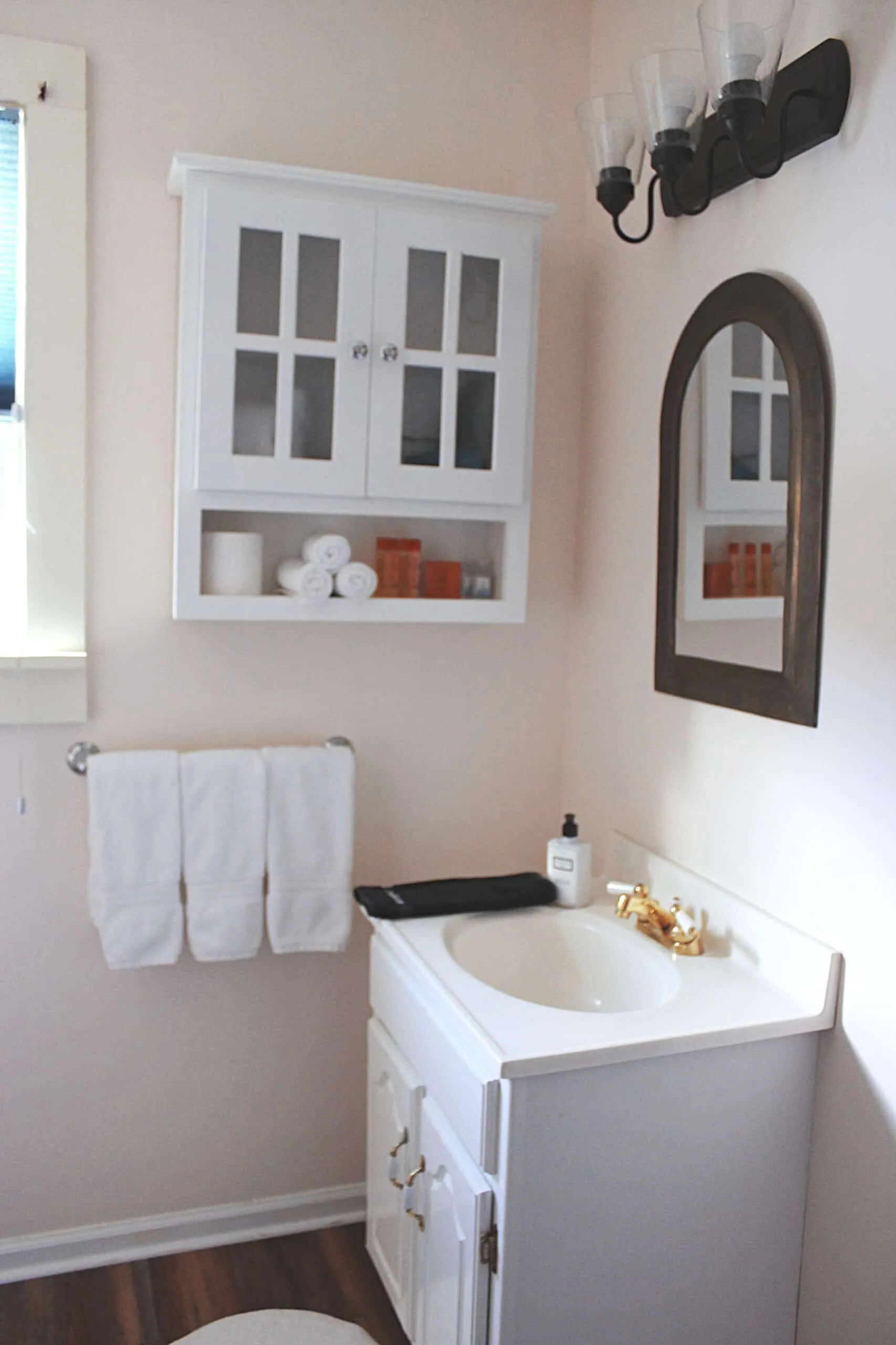 Private bathroom in the Tosca Suite with sink, mirror, towels, and storage cabinet